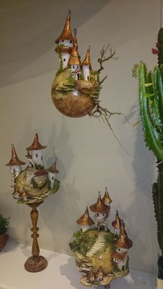 several ornaments are hanging on the wall next to a cactus