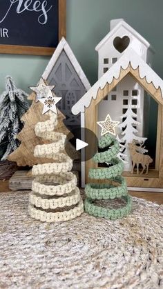 two small wooden christmas trees sitting on top of a table