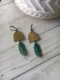 Adorable brass geometric earrings with dangle turquoise green patina leafs. Antique bronze nickel free lever back ear wires. Green Copper Earrings With Patina, Green Brass Dangle Earrings, Patina Brass Dangle Earrings, Green Bohemian Earrings With Patina, Green Patina Bohemian Earrings, Adjustable Patina Drop Earrings, Green Bohemian Patina Earrings, Bohemian Green Patina Earrings, Patina Earrings