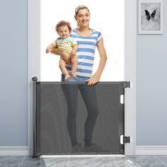 a woman holding a baby in her arms behind a screen door with the image of an adult and child on it