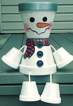 a snowman made out of cups sitting on top of a porch