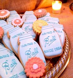 some decorated cookies on a plate with candles in the background