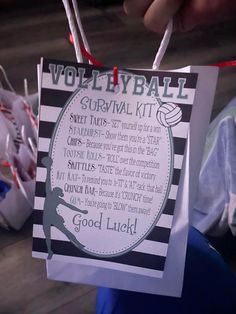 a person holding up a volleyball survival kit