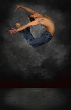 a shirtless man is doing a trick on his skateboard in the air over dark clouds