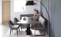 a woman sitting at a table in front of a lamp