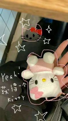 a hello kitty cell phone case sitting on someone's hand with stars around it