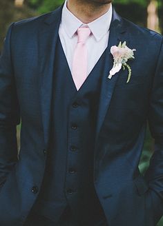 a man in a suit and pink tie