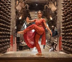 a woman in an orange outfit is dancing