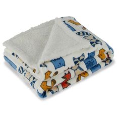 a white blanket with blue and yellow animals on it is folded up in front of a white background