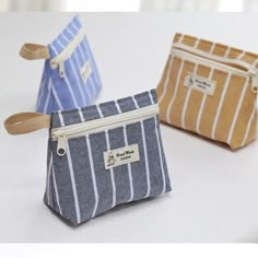 three small zippered pouches sitting next to each other on a white counter top