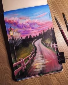 a painting of a country road with a lamp post on the other side and two paintbrushes next to it