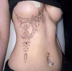 a woman's stomach with an intricate tattoo on it