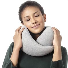 a woman holding her neck up to the side while wearing a gray and white scarf