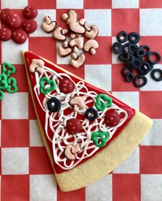 a slice of pizza on top of a checkered table cloth with pretzels