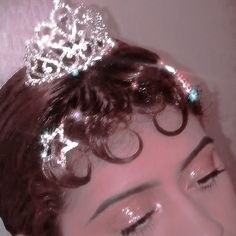 a woman with curly hair wearing a tiara