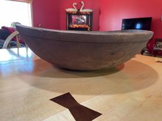 a large bowl sitting on top of a wooden table next to a tv set in a living room