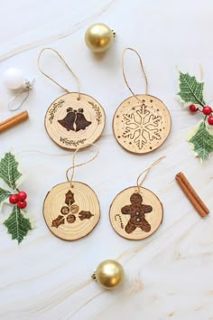 four wooden ornaments with christmas decorations around them on a table next to some cinnamon sticks