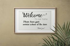 a framed sign that says, welcome to our home please leave your words and check at the door