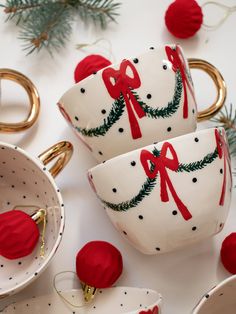 two white cups decorated with red bows and christmas decorations