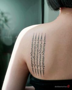 the back of a woman's shoulder with many words written in cursive writing