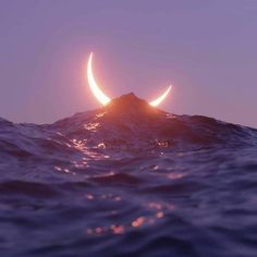 two crescents are seen over the ocean at sunset in this artistic photo taken from an island