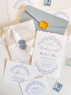 the wedding stationery is laid out on top of each other, including envelopes and stamps