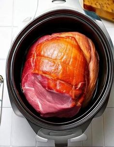 an open crock pot with ham in it