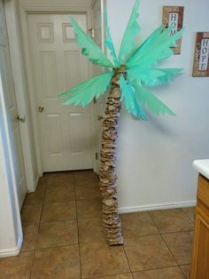 a palm tree made out of books is in the middle of a room with tile flooring