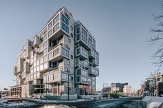 an apartment building on the corner of a street with people walking in front of it