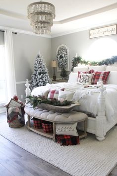 a bedroom decorated for christmas with red and white plaid bedding, pillows and blankets