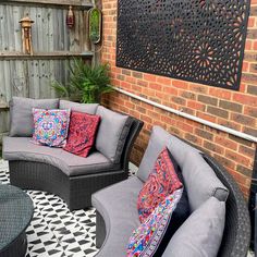 an outdoor patio with grey furniture and colorful pillows