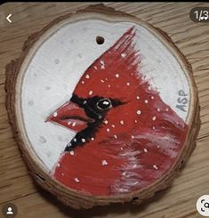 a red bird painted on a piece of wood