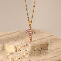 Looking for a cross necklace that's both pretty and versatile? The Pink Cross Necklace is the perfect choice for you! Adorned with lovely pink stones and set on a stylish gold beaded chain, this dainty necklace is a showstopper. Whether you wear it alone or pair it with other necklaces, it's sure to add a touch of elegance to any outfit. This can is made of stainless steel, so waterproof! The color remains perfect. Gold: 18k gold platingLength: 43+5cmMaterial: Stainless steel Waterproof jewelry Rose Gold Plated Cross Pendant Necklace, Pink Cross Pendant Necklace For Gift, Pink Cross Necklace For Gift, Pink Cross Necklace For Gifts, Rose Gold Plated Cross Necklace, Pink Cross Necklace, Pink Zircon, Stainless Steel Chain Necklace, Golden Rose