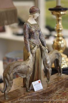 a figurine of a woman with a dog on a table next to a lamp