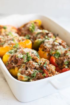 a casserole dish with meat and vegetables in it on a white counter top