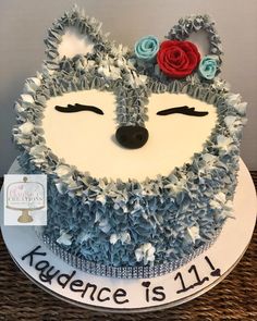 a cake decorated with blue and white frosting has a cat's face on it