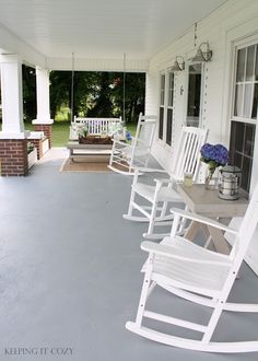 white rocking chairs are lined up on the porch