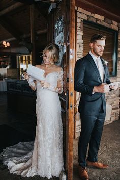 a bride and groom standing in front of a door at their wedding reception, looking at each other