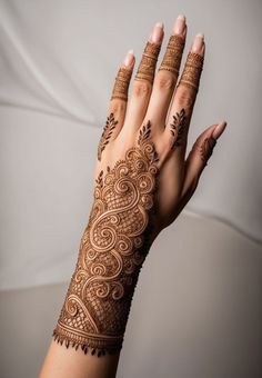 a woman's hand with henna tattoos on it