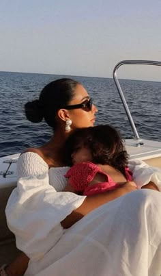 a woman and child sitting on the back of a boat