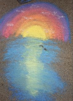 the sidewalk is covered with colored chalk and has a rainbow painted on it