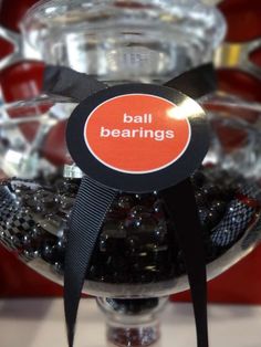 a bowl filled with black beads and a sign that says ball bearings on it