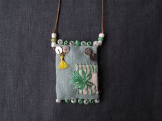 a green and white beaded necklace with an animal on it