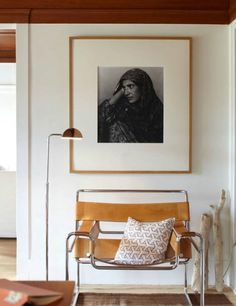 a living room with a chair and a painting on the wall