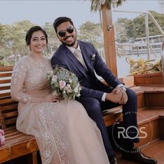 a man and woman are sitting on a bench smiling at the camera while holding hands