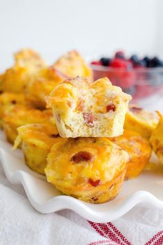 small muffins stacked on top of each other on a plate with berries in the background