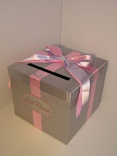 a pink and silver box with a bow on it