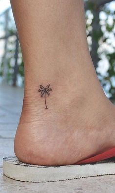 a small palm tree tattoo on the back of someone's foot is shown in this image