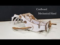 a close up of a piece of paper on a table with the words cardboard mechanical hand