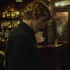 a young man standing in front of a bar